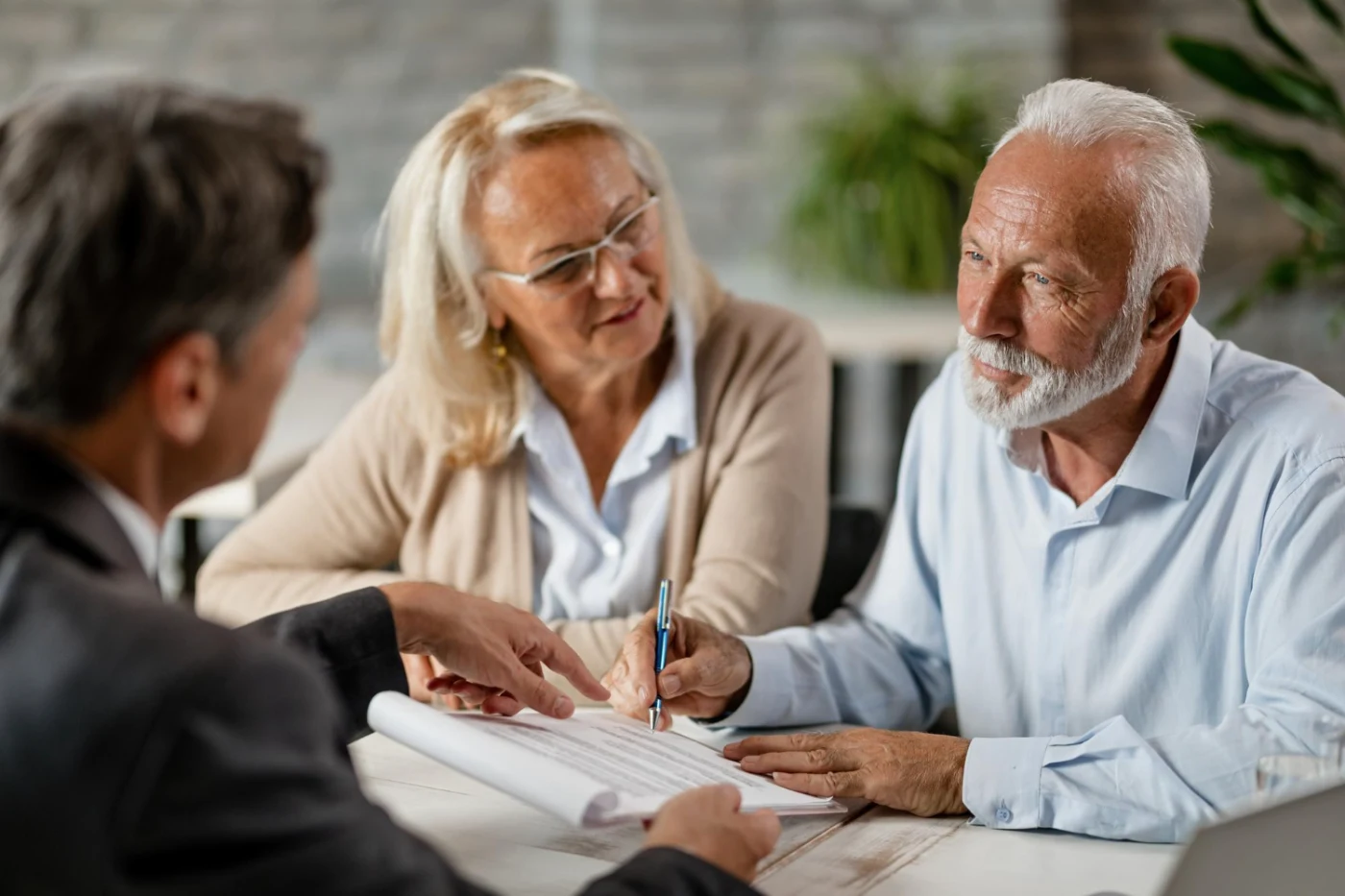 mature-couple-having-meeting-with-bank-manager-signing-lease-agreement-office-focus-is-mature-man